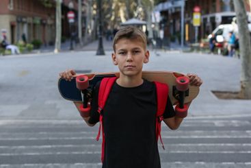 Handsome teenager standing with skateboard. Adolescent...