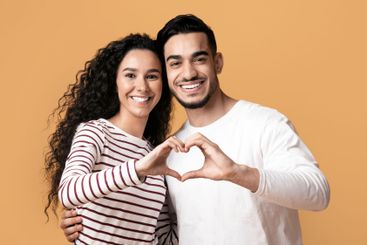 Portrait Of Romantic Arabic Couple Making Heart Gesture...