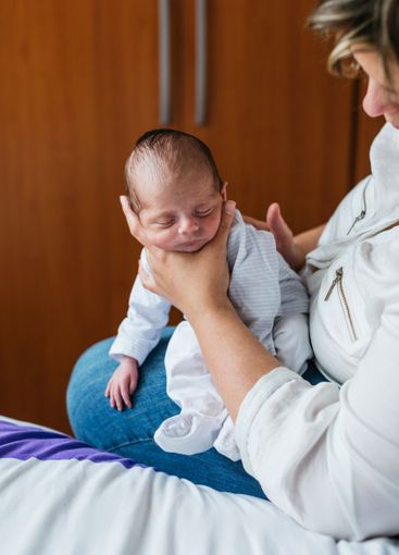 Mother holding her one month old baby son at home