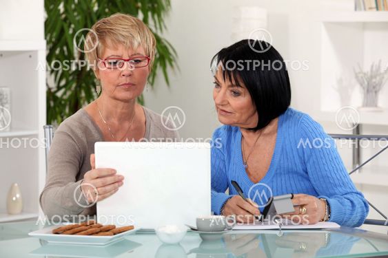 Two women with laptop and calculator