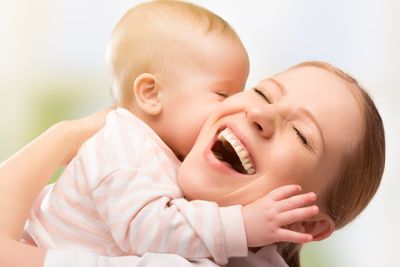 Happy cheerful family. Mother and baby kissing