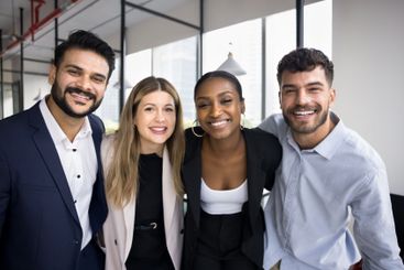 Four multi-national staff members posing together for...