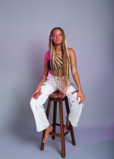 Brunette model with braids in her hair, wearing white...