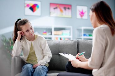 Psychiatrist comforting sad ADHD child during counseling...