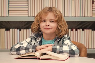 Kid reading book in a book store or library, Childhood...