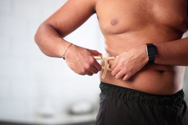 Fitness Trainer Helping Overweight Client Measure Progress