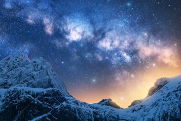 Glowing Milky Way over the mountains with snow covered peak