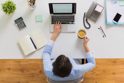 businesswoman with laptop and coffee at office