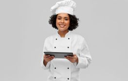 smiling female chef with tablet computer
