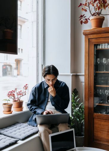 Thoughtful businessman with hand on chin working on...