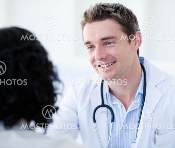 Portrait of a handsome doctor talking with his patient for the annual check-up