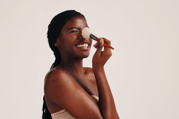 Brush, beauty and black woman in studio with face,...