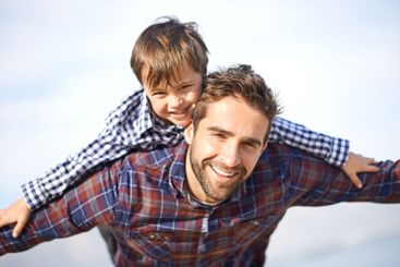 Portrait, father and son on beach with airplane game,...