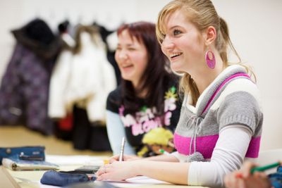 pretty, female college student sitting in a classroom...