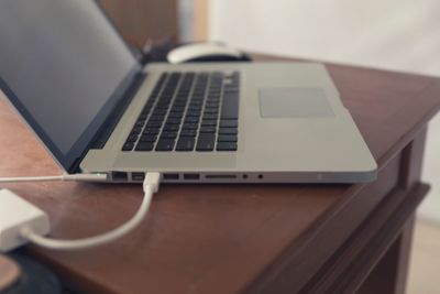 laptop computer, mouse and eyeglasses on wooden desk...