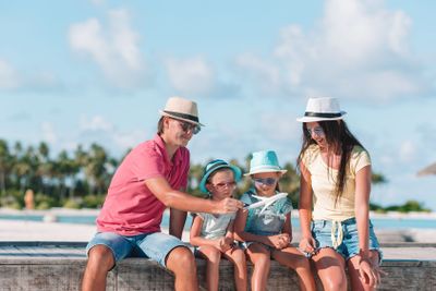 Family with two kids play run on tropical beach
