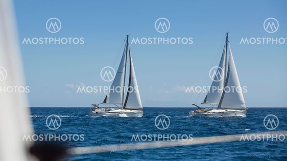 Sailing luxury yachts in the open sea in calm weather.