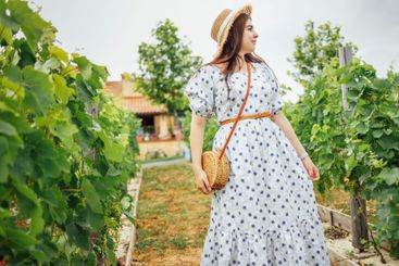 Young enchanting woman in summer sundress with floral...