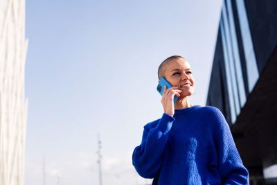 woman with buzz cut talking happy on mobile phone
