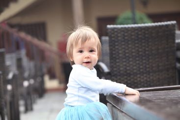 Curious baby girl 1 year old playing in the yard outdoors
