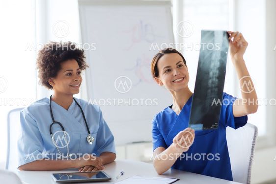 happy female doctors with x-ray image at hospital