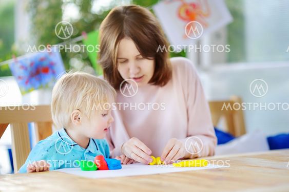 Cute little boy drawing and painting with colorful...
