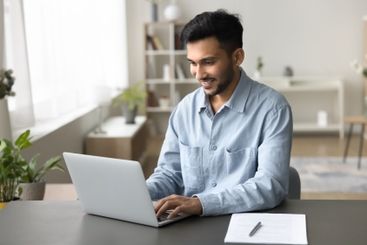 Busy young man type on notebook at home office desk