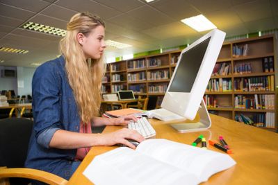 Student studying in the library with computer