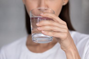 Thirsty young woman drinking pure mineral water