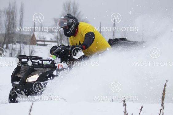 The quad bike's driver rides over snow track