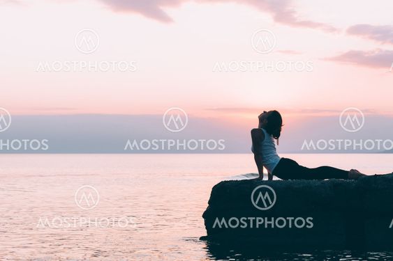 Young woman doing yoga by the sea