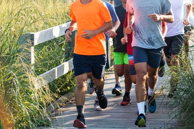 Group of boys running on a boardwalk at the beach