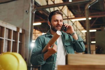 Business, phone call and man in workshop, smile and...