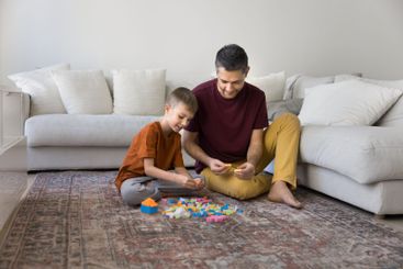 Father and son building with colorful construction blocks