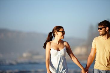Beach, holiday and happy couple holding hands, walking...
