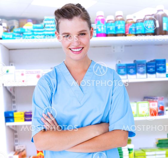 Composite image of smiling nurse in blue scrubs posing with arms crossed
