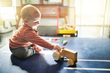 Baby boy, playing and tractor toys in home with morning...