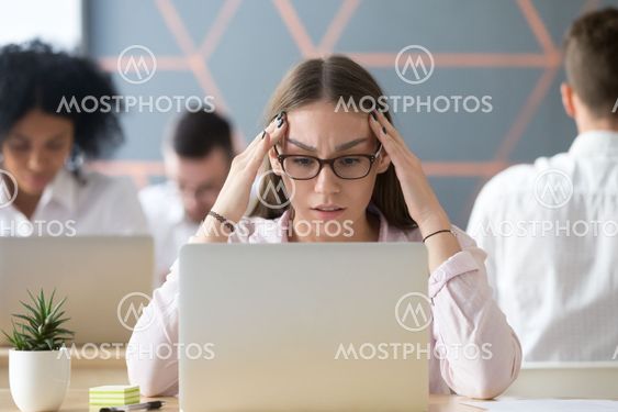 Stressed student concerned about hard online task looking at lap