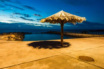 Coastal view at dusk in Madeira featuring a thatched...