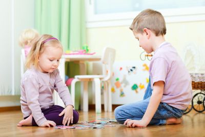 Brother and sister solving puzzle