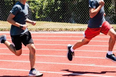 Two high school boys running fast on a track