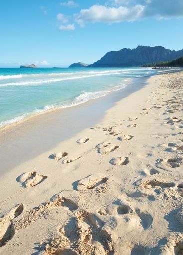 Ocean, sand and travel with footprints at beach for...