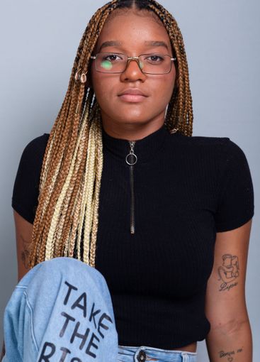 Beautiful brunette with braids in her hair, wearing...