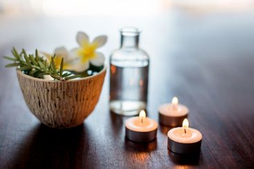 Flower, candles and rosemary in spa for aromatherapy,...
