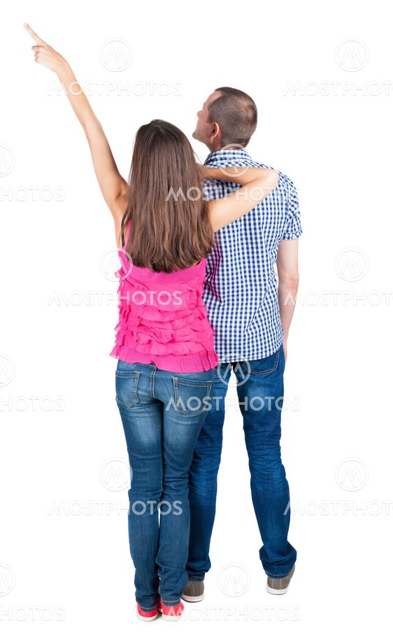 young couple pointing at wal Back view
