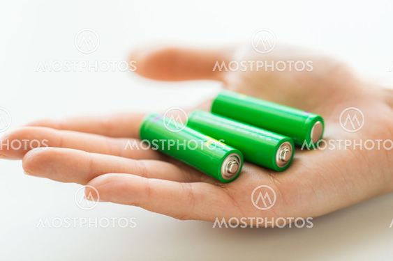 close up of hand holding green alkaline batteries