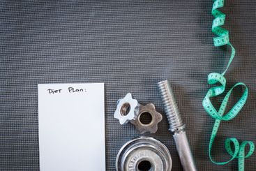 Fitness concept with dumbbells and measuring tape