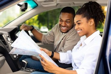Black Couple Sitting In Car Holding Map Choosing Travel...