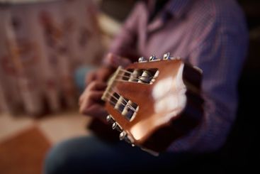 Close-up of a guitar being played by a person indoors
