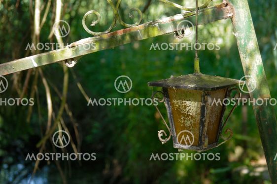 vintage style street light with crown on the top. Beautiful historical retro metal Streetlight green tree background.